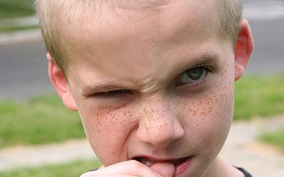 Child boy bitting his nail