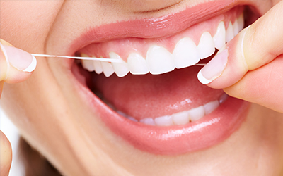 A woman flossing her teeth