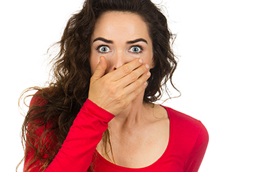 A woman covering her mouth with bad breath