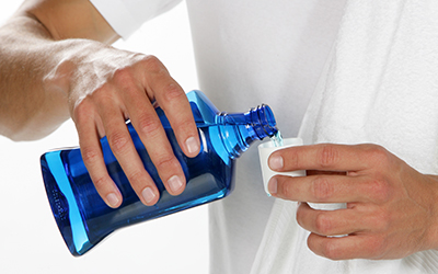 man pouring mouthwash into a cup