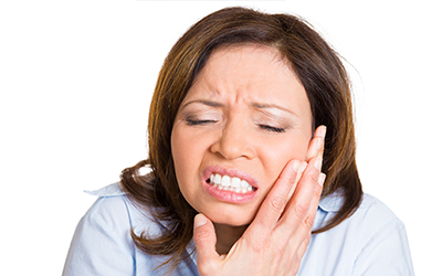 A woman holding her jaw in pain