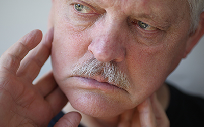 Man with fingers on painful jaw